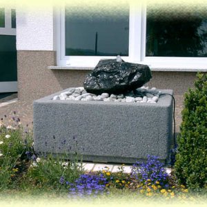 Basalt-Quellstein       auf hellgrauem Zierkies in Basalt-Becken 